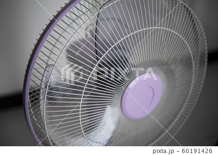 Modern violet electric fan in a living room saving peoples from hot temperature in summer days. 60191426