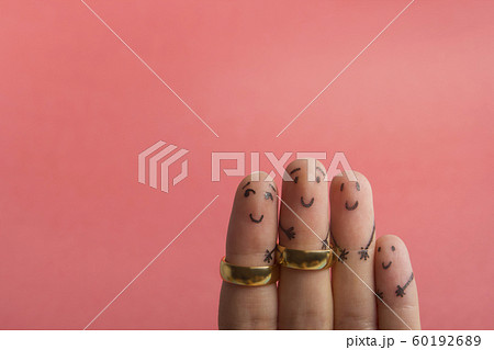 Painted happy fingers smiling in love against pink background with copy space for ad text. Marriage wedding rings 60192689