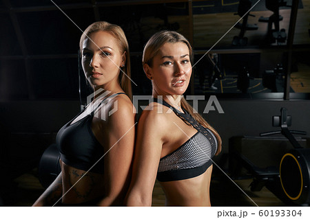 Brutal fitness two female friends with a muscular in the gym. Sports and fitness - concept of healthy lifestyle. Fitness woman in the gym. 60193304