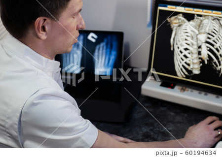 in medical laboratory patient undergoes MRI or CT scan process under Supervision of Radiologist in Control Room, He Watches Procedure and Monitors skeleton and ribs of the patient 60194634