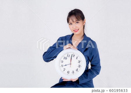 Beautiful portrait young business asian woman smiling holding clock isolated on white background 60195633