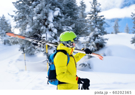 Portrait of sportive man in helmet with skis on his shoulder Portrait of sportive man in helmet with skis on his shoulder 60202365