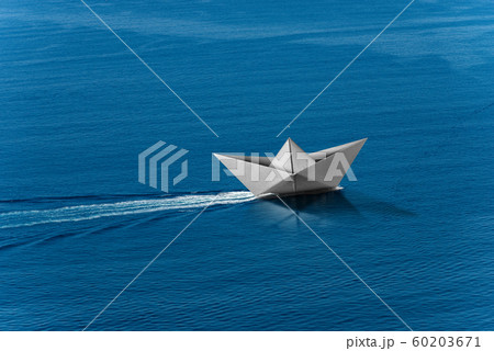 White paper boat with wake in the blue sea - Aerial view 60203671