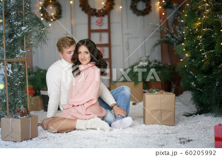 Married young couple lovers on the background of a Christmas tree decorated with a garland 60205992
