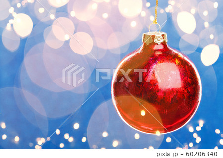 Red Christmas ball on blue bokeh background 60206340