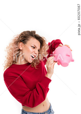 cheeky attractive girl with a piggy bank in hands on a white studio background cheeky attractive girl with a piggy bank in hands on a white studio background 60207087
