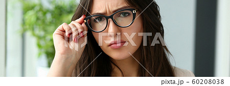 Young beautiful business woman holding glasses Young beautiful business woman holding glasses 60208038