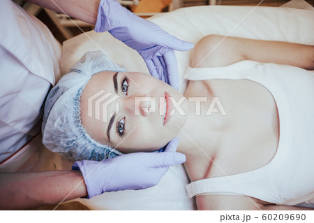 Cosmetology doctor makes woman treatments facial massage 60209690