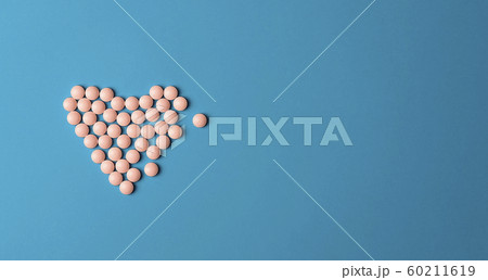Medical background. Pink Pills in form of heart on blue background Medical background. Pink Pills in form of heart on blue background 60211619