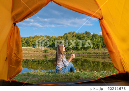Camping on lake shore at sunset, view from inside 60211678