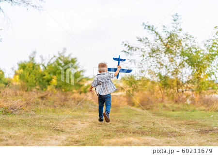 Young boy play with toy airplaine in hands. Happy 60211679