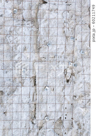 Building background prepared surface of the facade wall of the building with a fixed rusted mesh for cementing and painting the facade. Cement fixing net attached to a rough cement wall 60211749