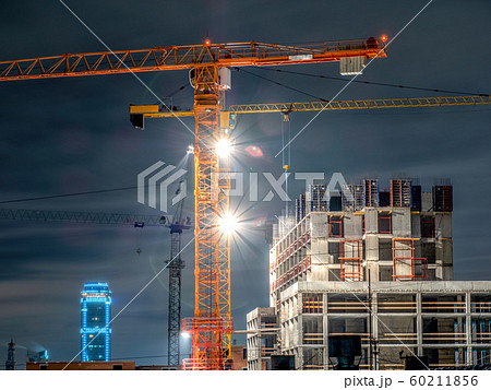 Tower cranes at a construction site in the night Tower cranes at a construction site in the night 60211856