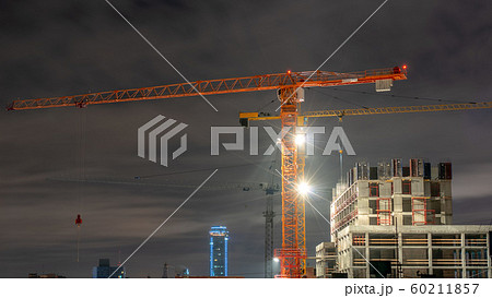Tower cranes at a construction site in the night Tower cranes at a construction site in the night 60211857