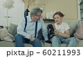 Teenage boy is showing VR-glasses to his grandfather 60211993