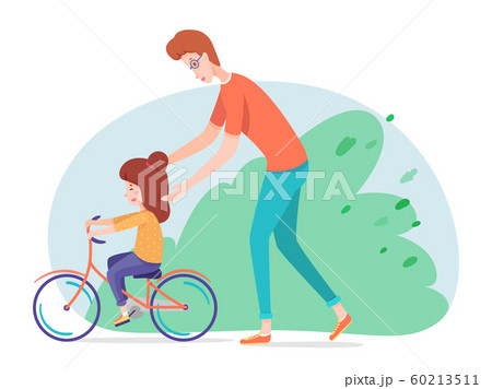 Father teaching daughter riding bicycle in yard 60213511