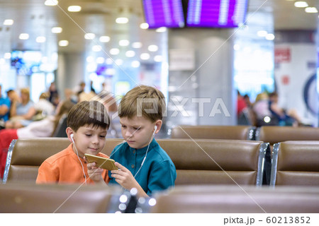 Two little boy sitting in an airport departure Two little boy sitting in an airport departure 60213852