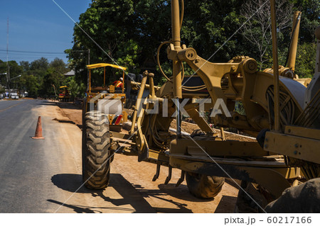 Grader is working on road construction. Grader industrial machine on construction of new roads. Heavy duty machinery working on highway. Construction equipment. Compaction of the road. Grader is working on road construction. Grader industrial machine on construction of new roads. Heavy duty machinery working on highway. Construction equipment. Compaction of the road. 60217166