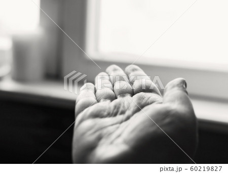 Open human hand is turned toward window 60219827