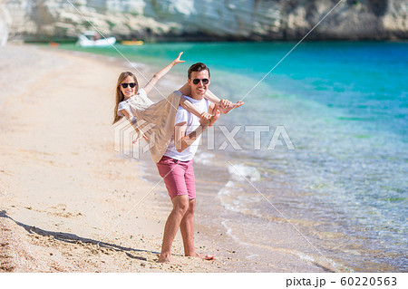 Little girl and happy dad having fun during beach vacation 60220563