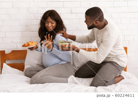 Husband begging his pregnant wife eat healthy food 60224611