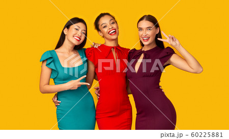 Three Diverse Girlfriends Gesturing Victory Sign Posing On Yellow Background 60225881