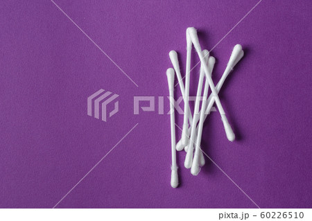 White plastic cotton swabs on purple background White plastic cotton swabs on purple background 60226510
