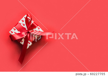 Christmas giftbox with red ribbon on red surface. Christmas giftbox with red ribbon on red surface. 60227705