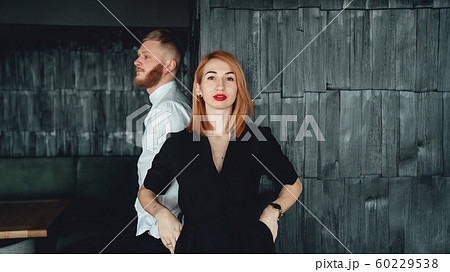 A young woman and her boyfriend are posing for the camera indoors. 60229538