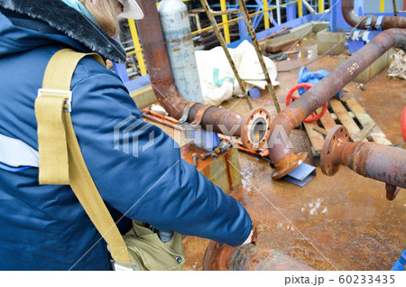 Working repairs rusty pipes and flanges at the  60233435