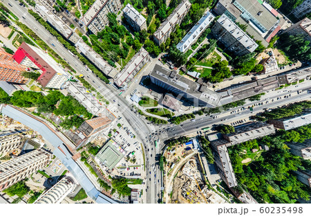 Aerial city view with crossroads and roads, houses, buildings, parks and parking lots. Sunny summer Aerial city view with crossroads and roads, houses, buildings, parks and parking lots. Sunny summer 60235498