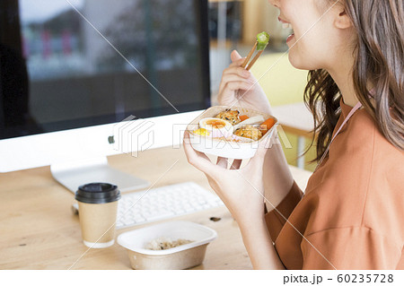 PCの前で食事をする働く女性　ビジネスシーン 60235728