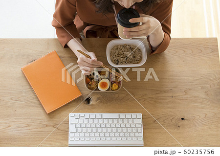 PCの前で食事をする働く女性　ビジネスシーン 60235756