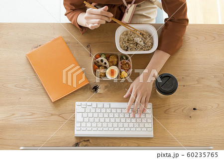 PCの前で食事をする働く女性　ビジネスシーン 60235765
