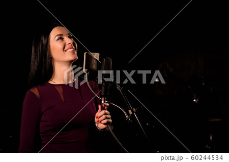 Singer recording a song in music studio. 60244534