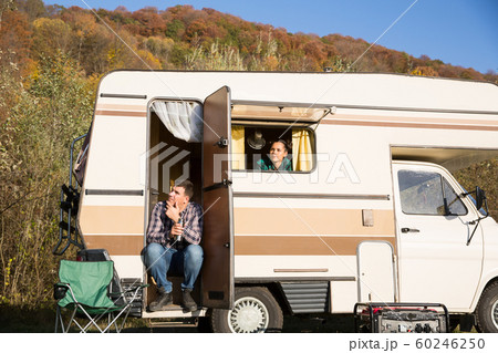 Couple admiring nature from inside of their retro camper van 60246250