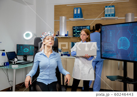 Doctor tracking live data on a laptop during a girl's brain scan procedure Doctor tracking live data on a laptop during a girl's brain scan procedure 60246443