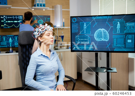 Female patient who is in a neurology clinic and her brain is being scanned 60246453