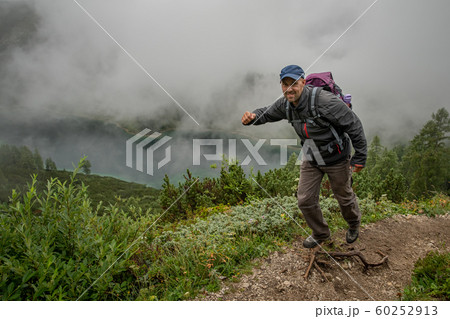 hikers in the austrian alps walk on mountain hiking trails in the woods around the lakes 60252913