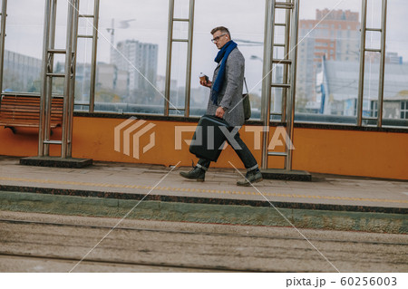 Handsome elegant man walking on the street 60256003
