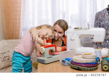 seamstress woman works and plays with daughter seamstress woman works and plays with daughter 60256787