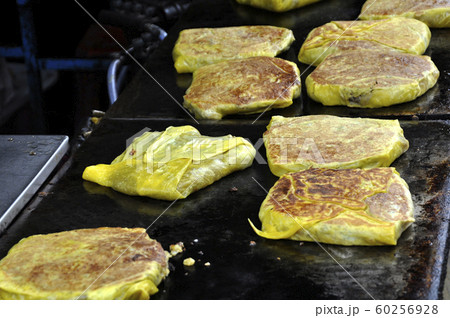 Malaysian street food called Murtabak. Cook by Hawkers. In it there is a mixture of meat, eggs and onions. Eaten with a special gravy. 60256928
