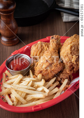 fried chicken with french fries in plastic basket fried chicken with french fries in plastic basket 60257381