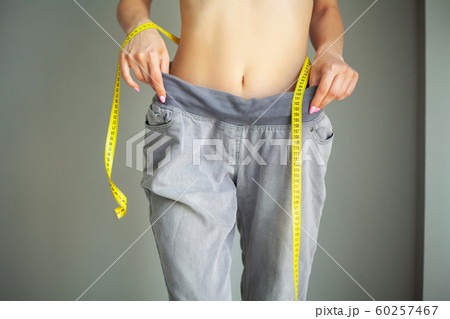 Diet. Woman in Sportswear Measuring Her Waist. Dieting concept Diet. Woman in Sportswear Measuring Her Waist. Dieting concept 60257467