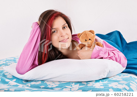 Young girl waking up with her teddy bear Young girl waking up with her teddy bear 60258221
