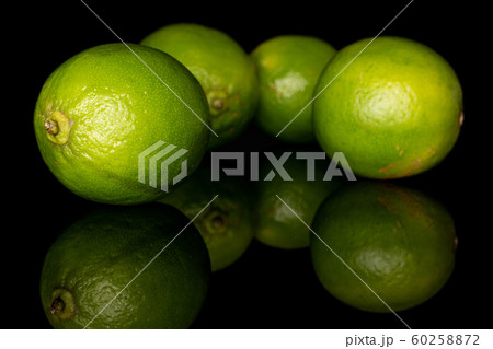 Green sour lime isolated on black glass 60258872