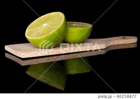 Green sour lime isolated on black glass Green sour lime isolated on black glass 60258877