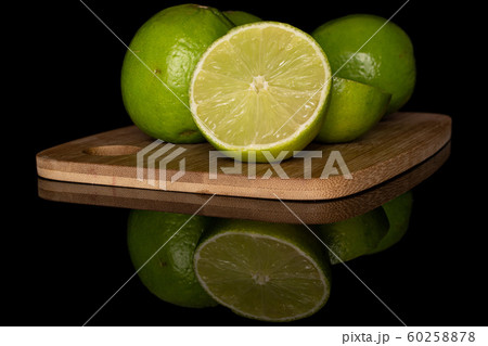 Green sour lime isolated on black glass Green sour lime isolated on black glass 60258878