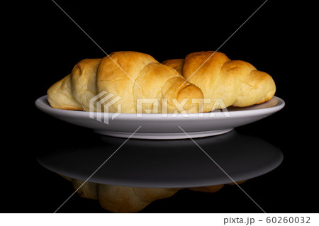 Sweet mini croissant isolated on black glass Sweet mini croissant isolated on black glass 60260032