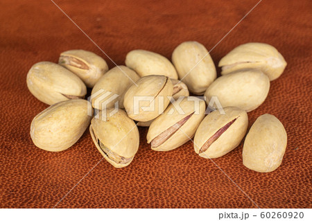 Salted pistachio on cognac leather Salted pistachio on cognac leather 60260920